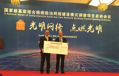 國際奧比斯北亞區總監司馬橋（George Smith）從捷成集團董事總經理海寧先生(Helmuth Hennig)接過捷成集團捐贈的740萬元人民幣支票